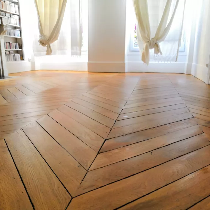 Parquet chevron ancien restaur&eacute; devant une chemin&eacute;e
