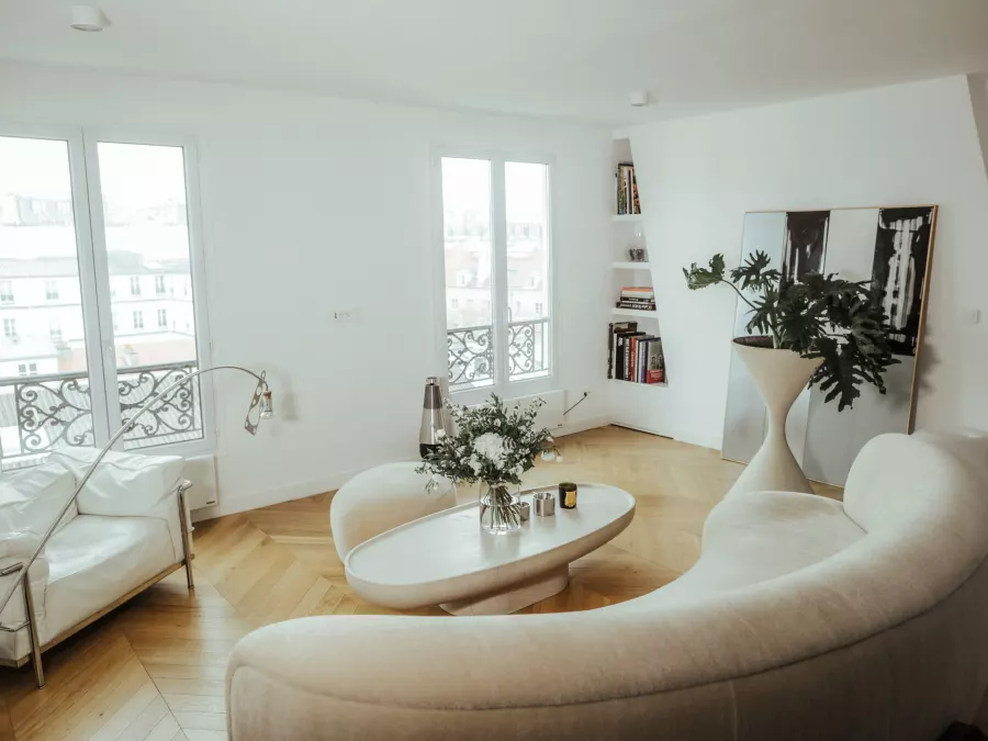 Salon rénové avec parquet chevron et vue sur Paris