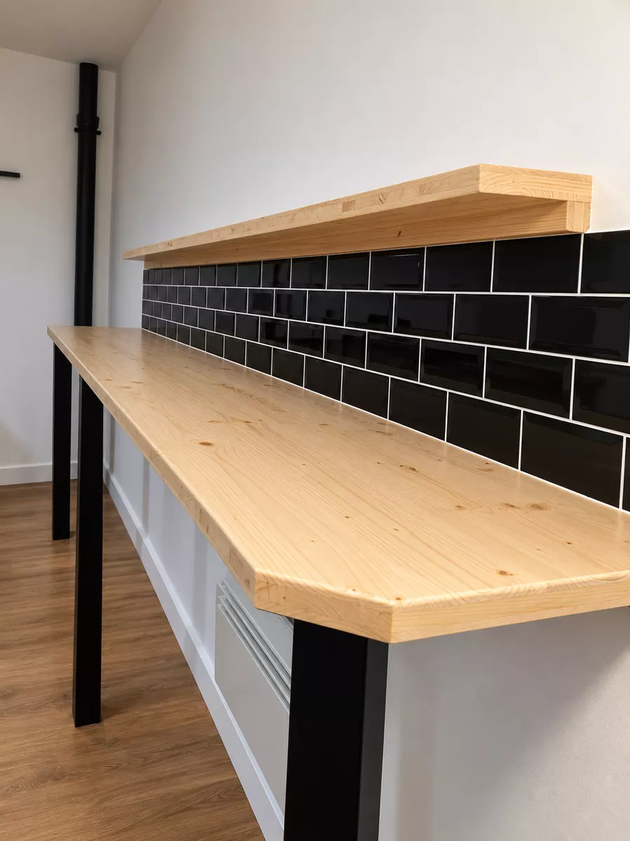 Plan de travail en bois au-dessus d'une crédence en carrelage noir