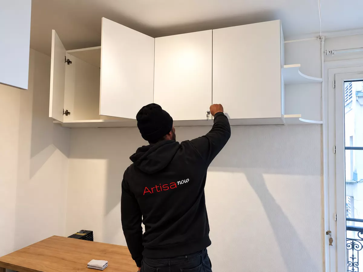 Pose d&rsquo;un meuble haut sur mesure en cours de chantier